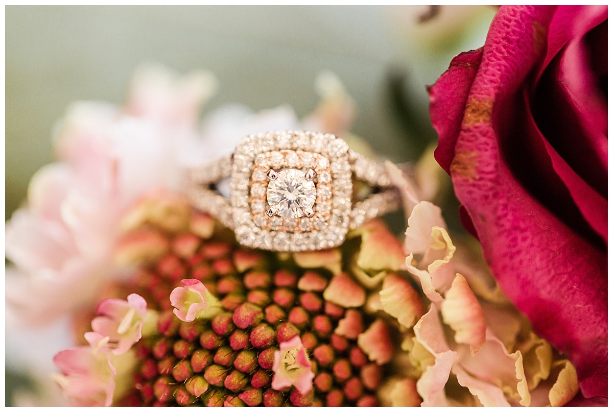 halo engagement ring on flowers