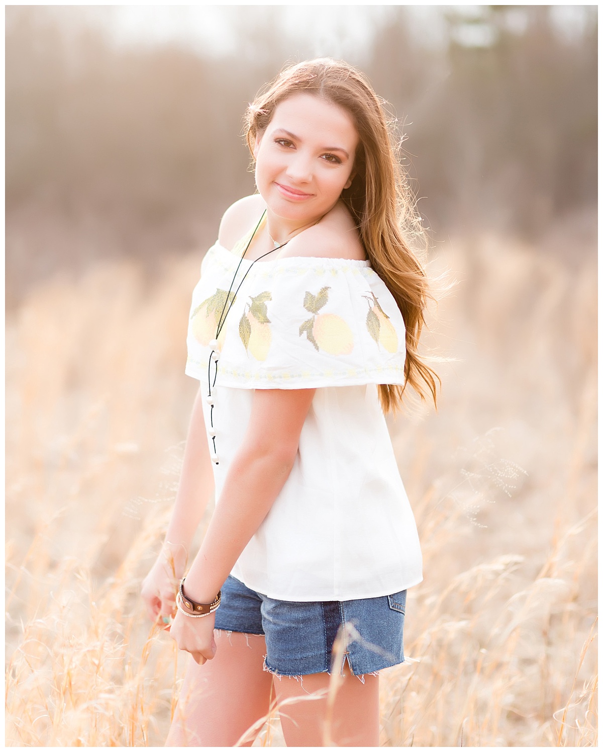 senior girl-3/4 length-standing in field of wheat colored grass