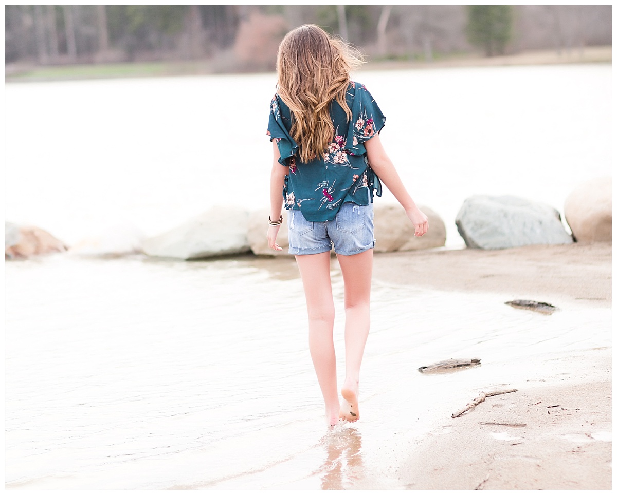 senior girl walking away along shore