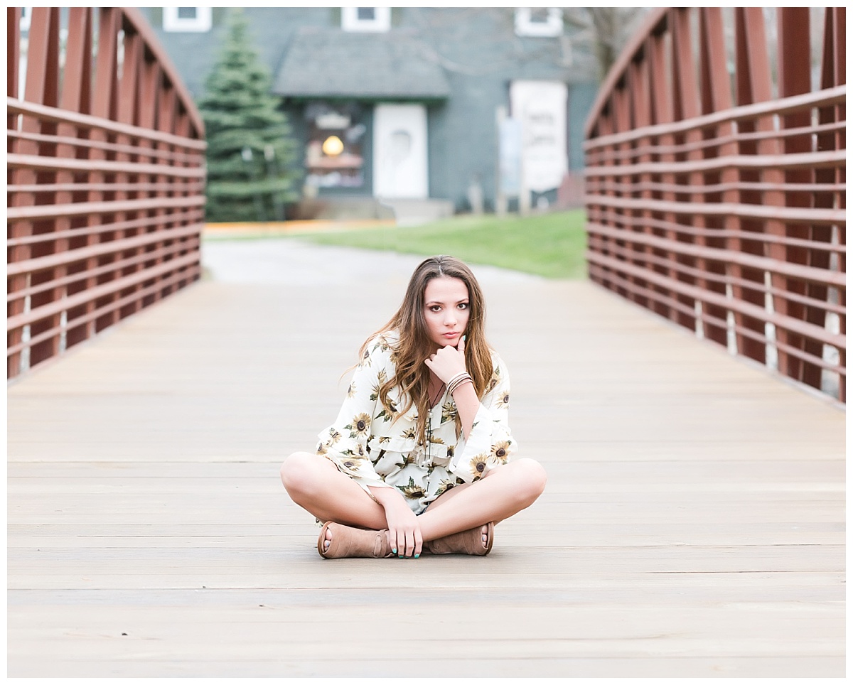 senior girl sitting on walking bridge
