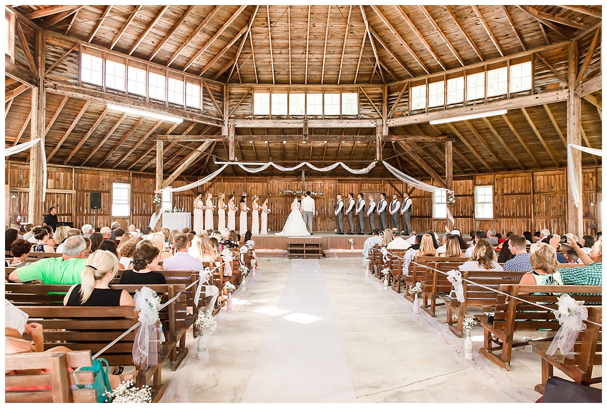 wedding ceremony full bridal party in view showcasing high wooden ceiling of The Tabernacle Monroe, IN 
