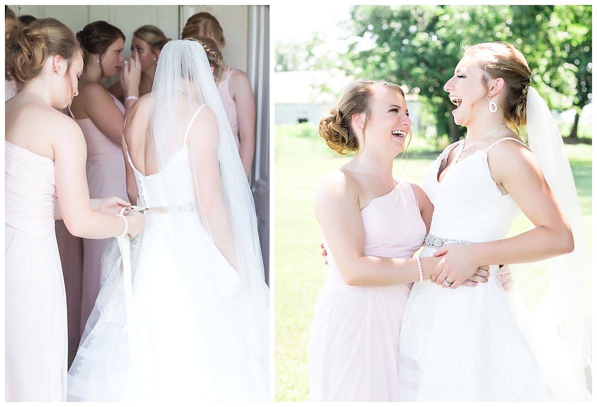 bridesmaid in pink dress tying bow of brides wedding dress | bridesmaid and bride
