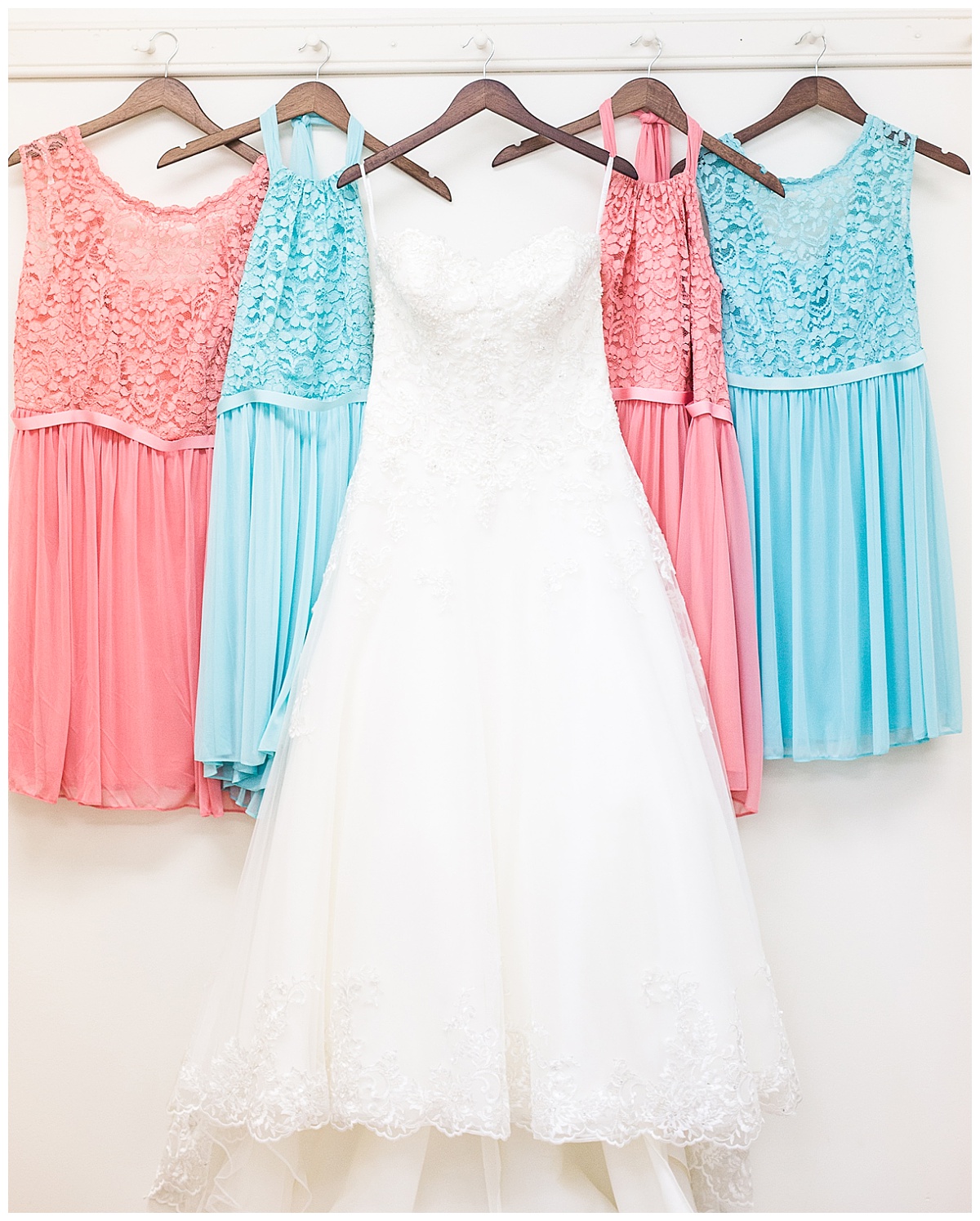 wedding gown hung with teal and coral bridesmaids dresses