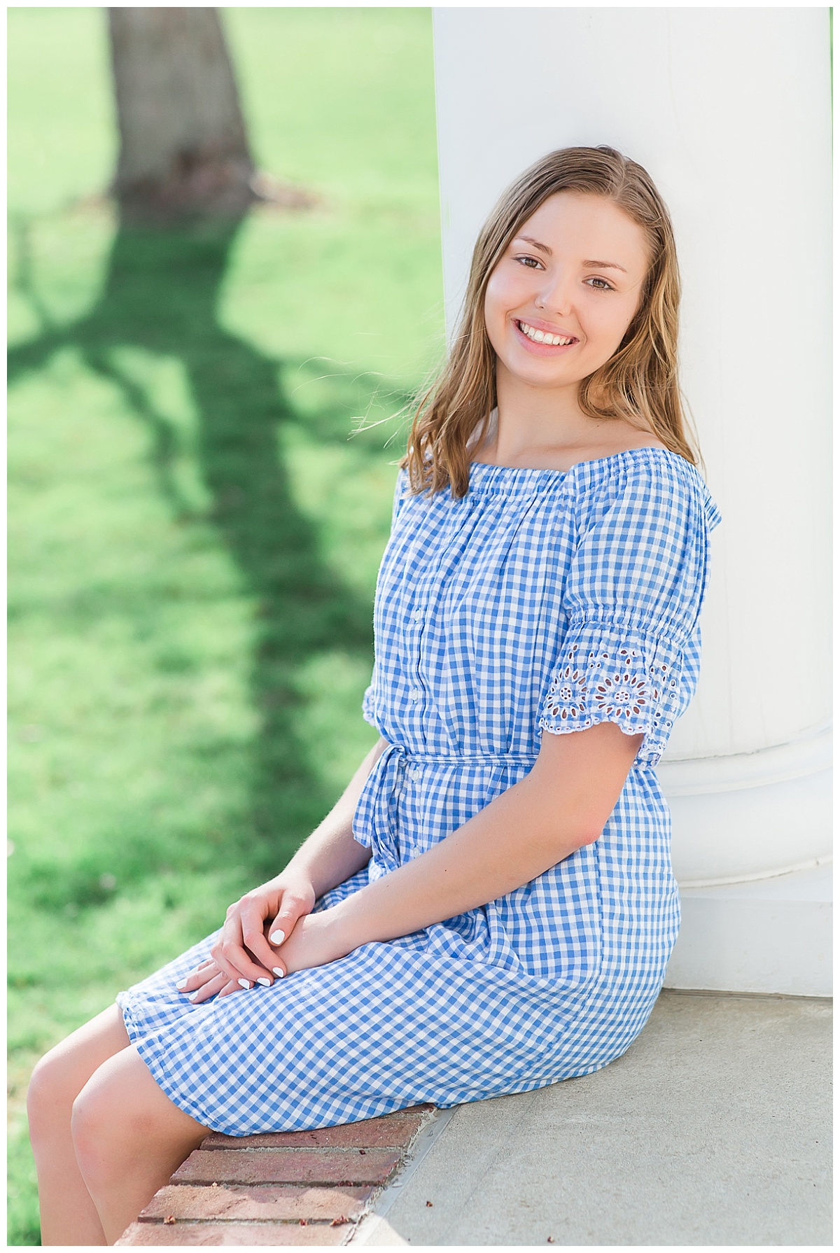 senior girl by white column of southern style porch