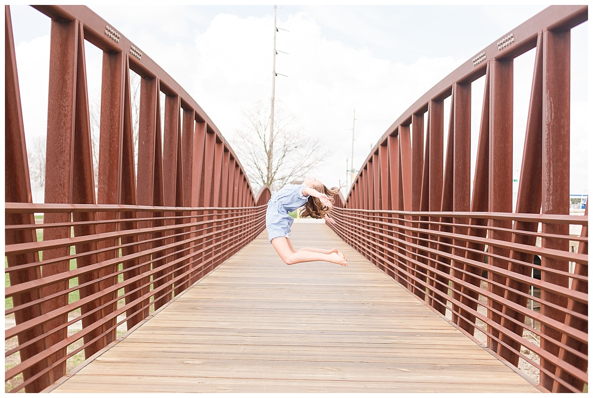 senior girl jumping on bridge
