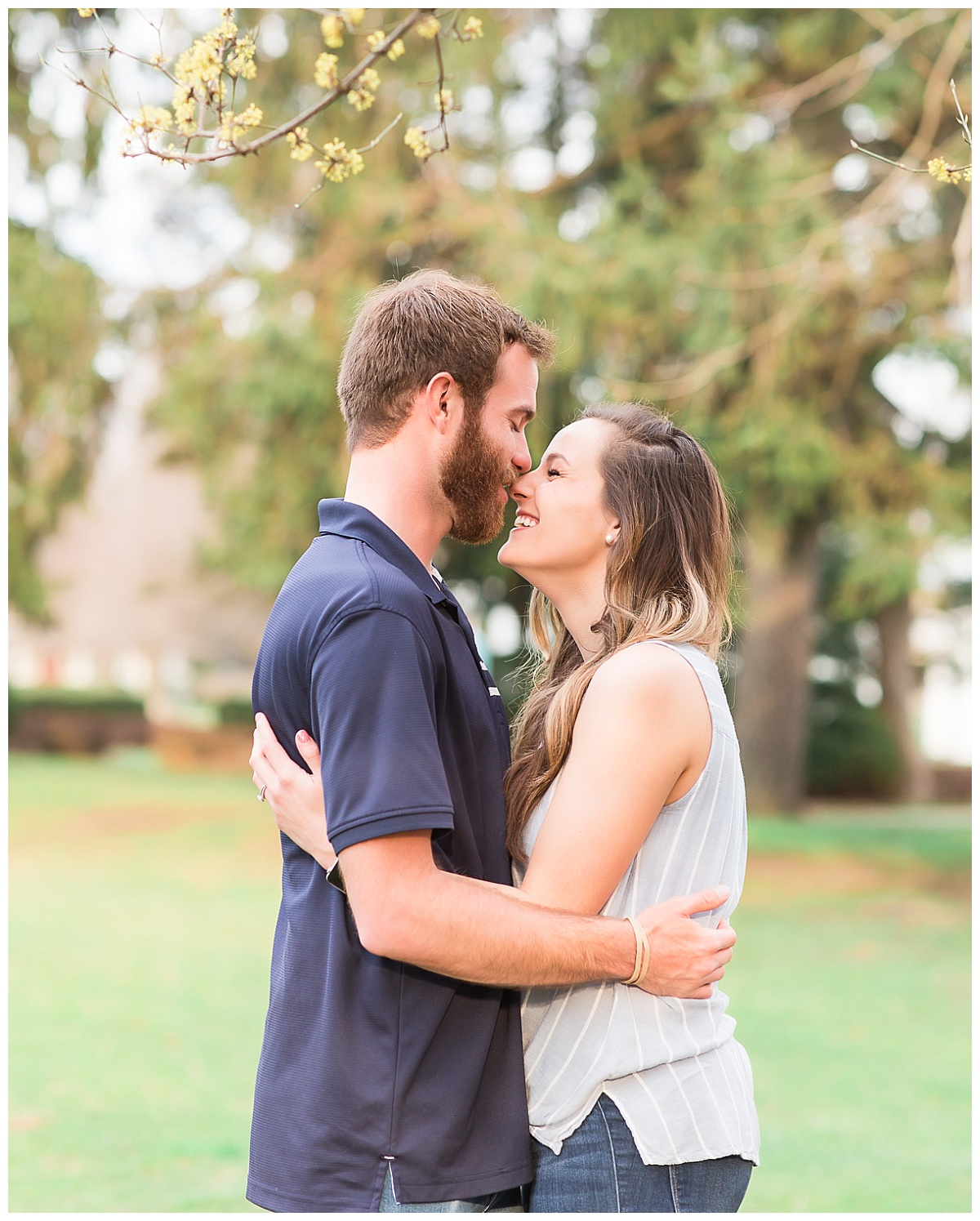 close up of couple standing together in front of trees
