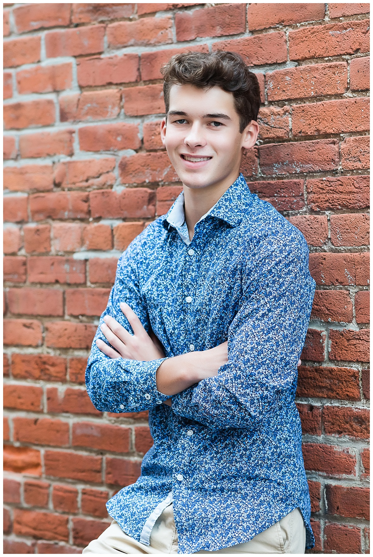 Senior guy in front of brick wall photo by Simply Seeking Photography
