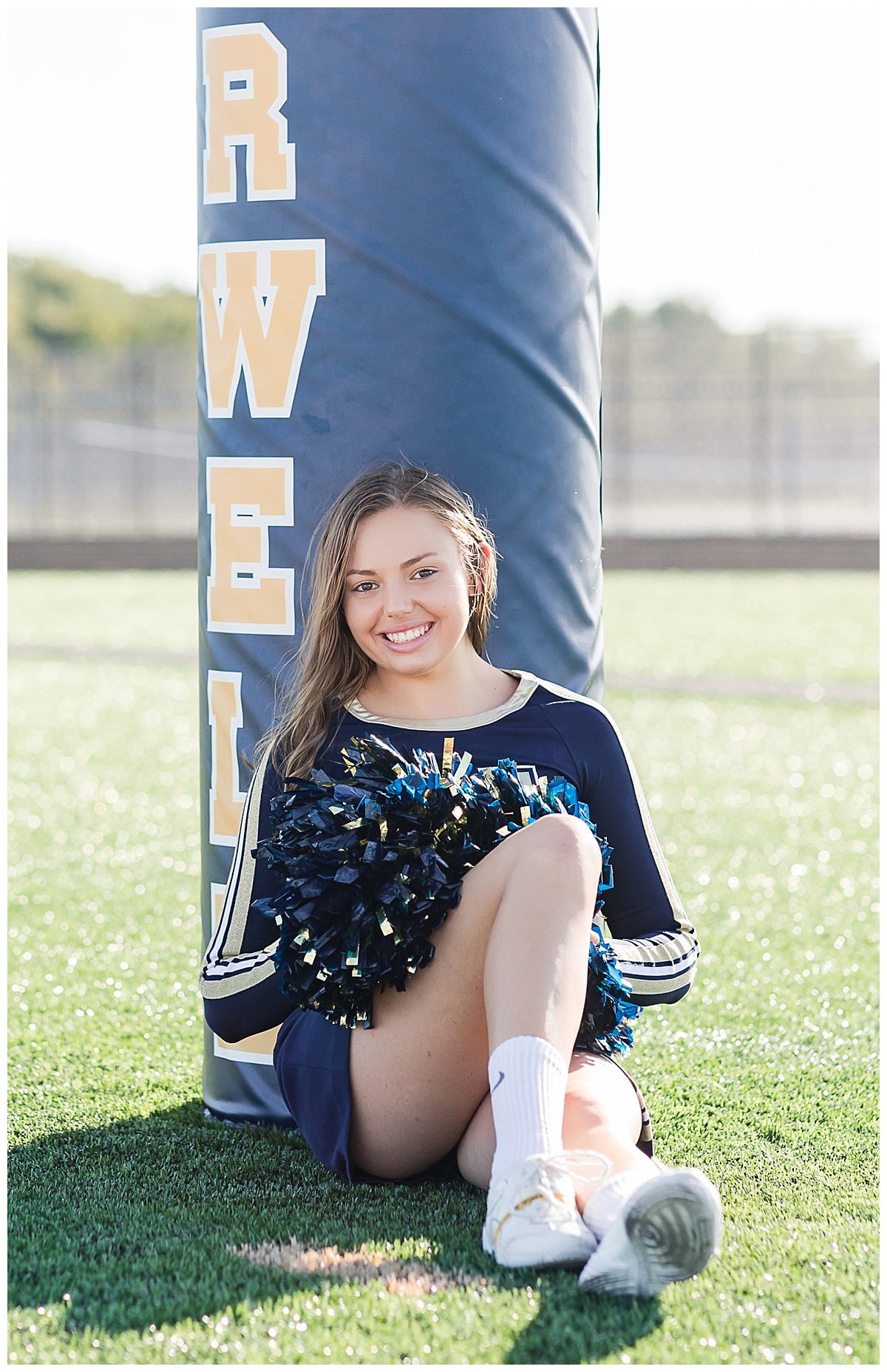 Senior cheerleader on football field photo by Simply Seeking Photography