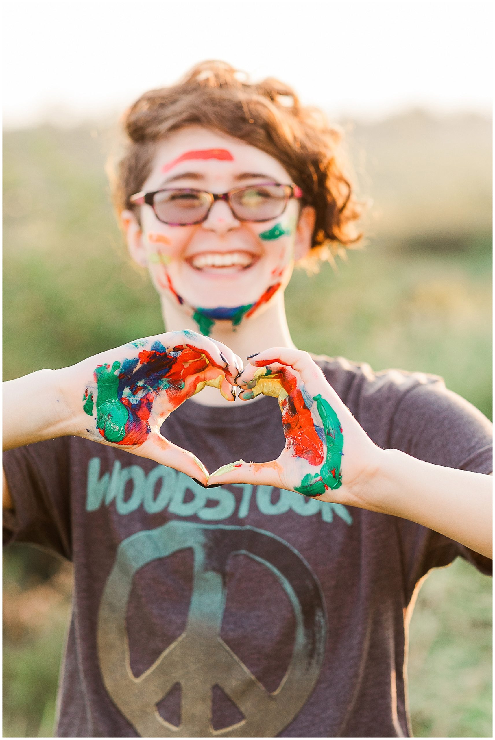 colorful senior session girl with painted hands and face